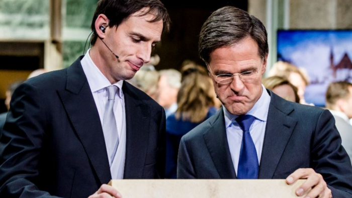 Two men looking down at open suitcase